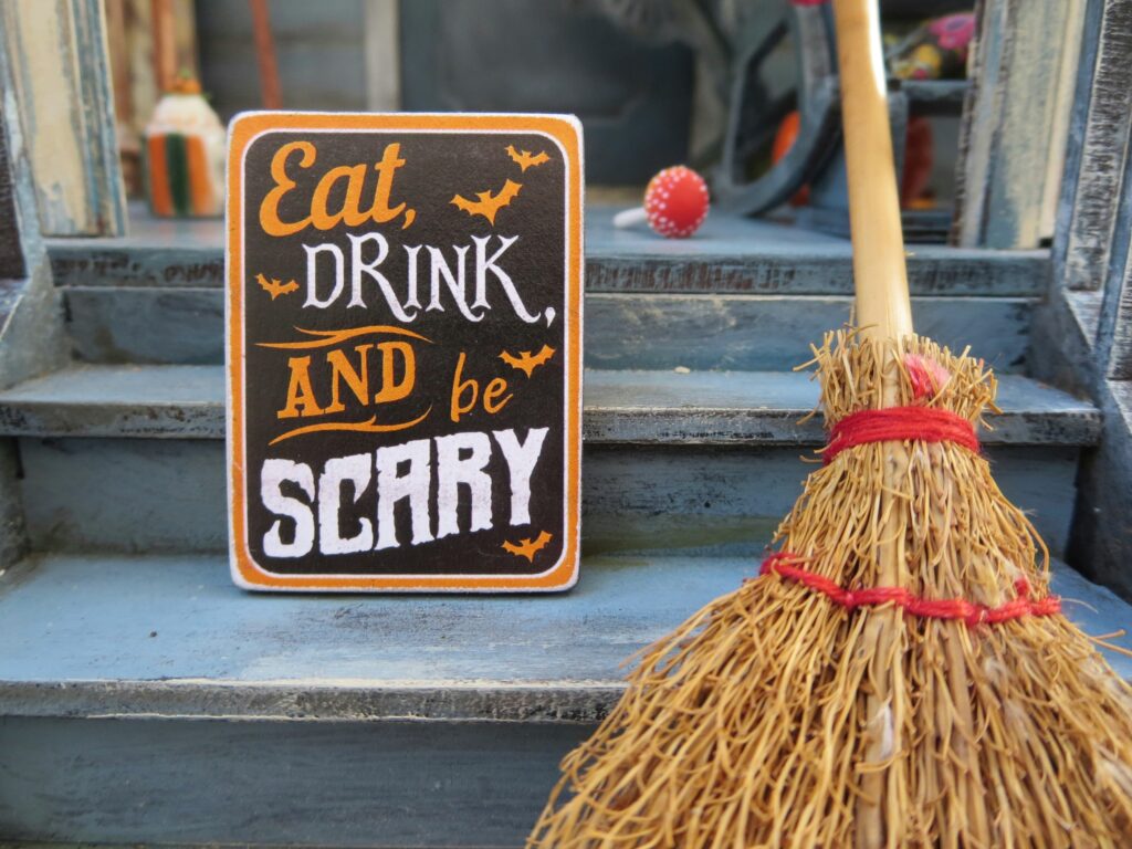 Witches broom next to decorative Halloween sign